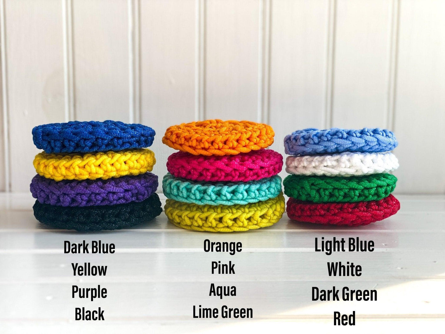 Three Stacks of Handmade Colorful Crochet Dish Scrubbies labeled with colors with white background