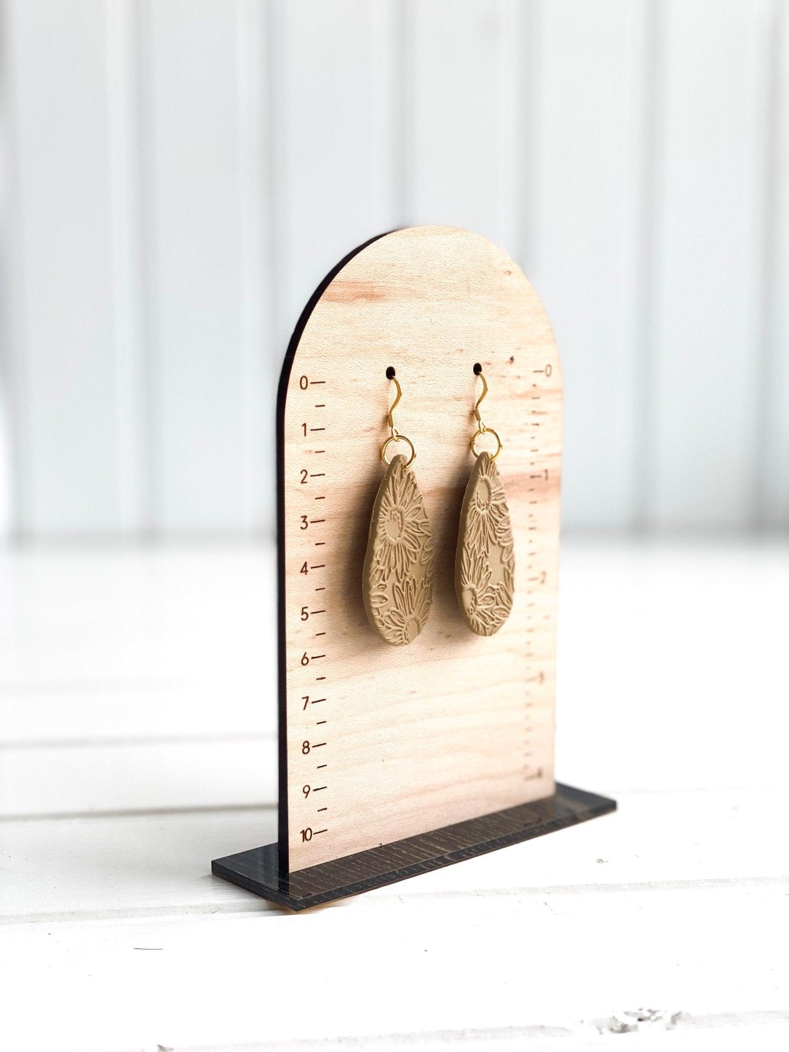 Handmade, Neutral Color Teardrop Shaped Earrings with Embossed Daisy Print with Gold Surgical Steel Ear Wires on Stand