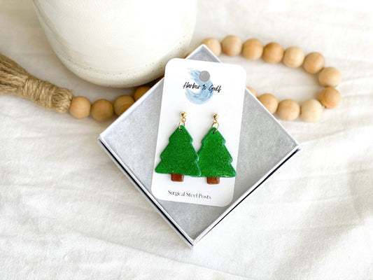 handmade earrings that are sparkly green christmas trees attached to gold ball posts on earring card in white gift box