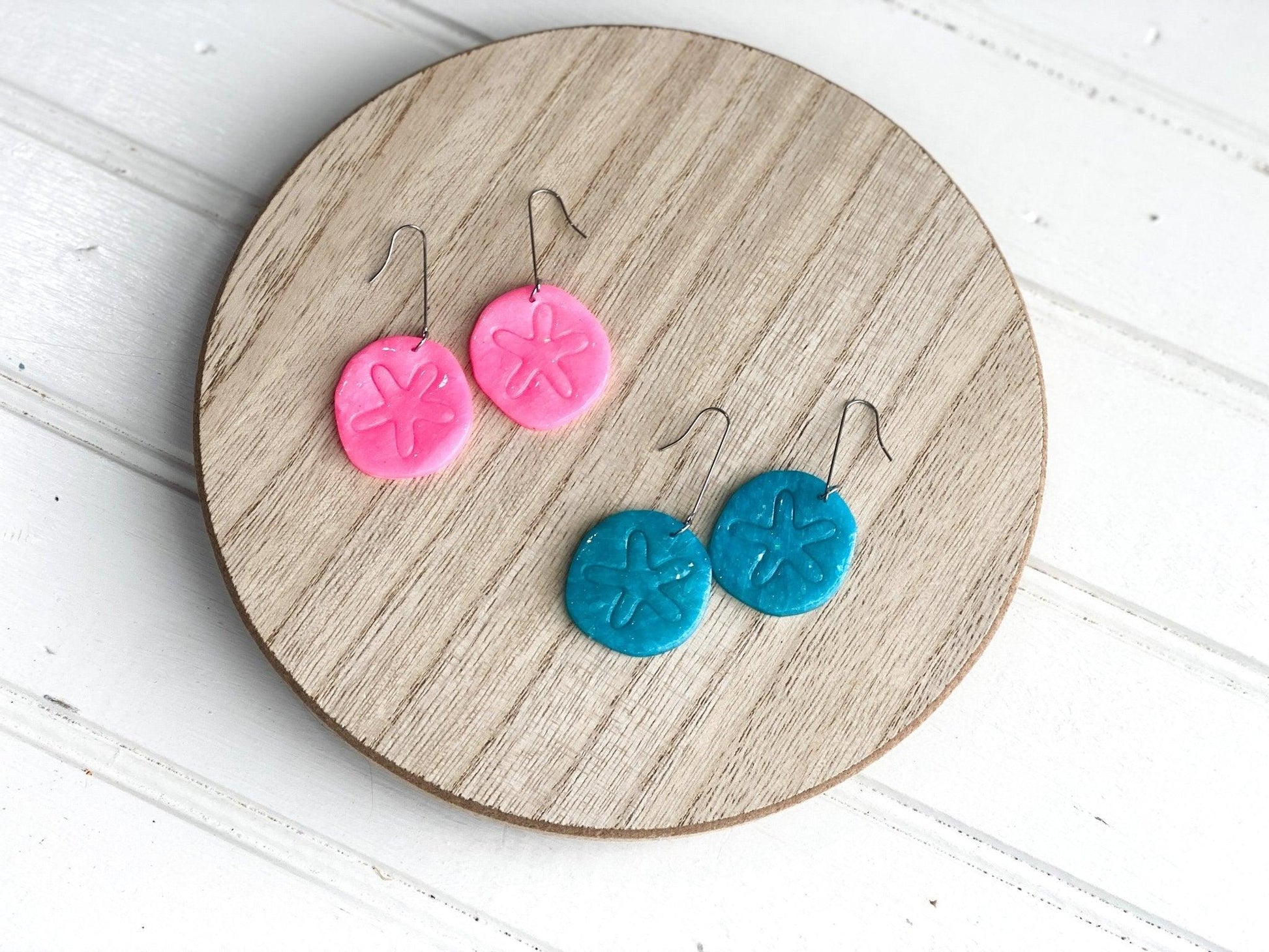 Pink and Teal Handmade Sand Dollar Earrings on Long Surgical Steel Ear Wires displayed Wooden Display Circle