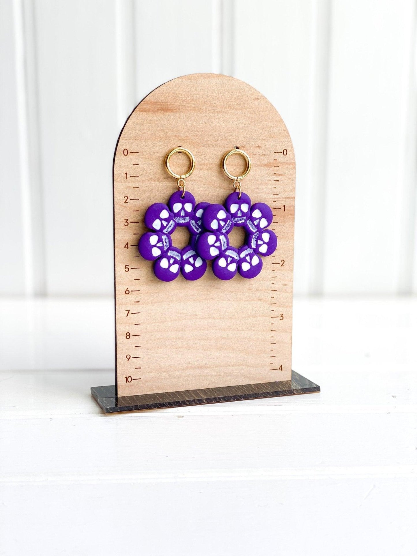 Handmade Purple and White Skull Circle Earrings with Gold Surgical Steel Circle Stud Tops on Earring Measurement Stand