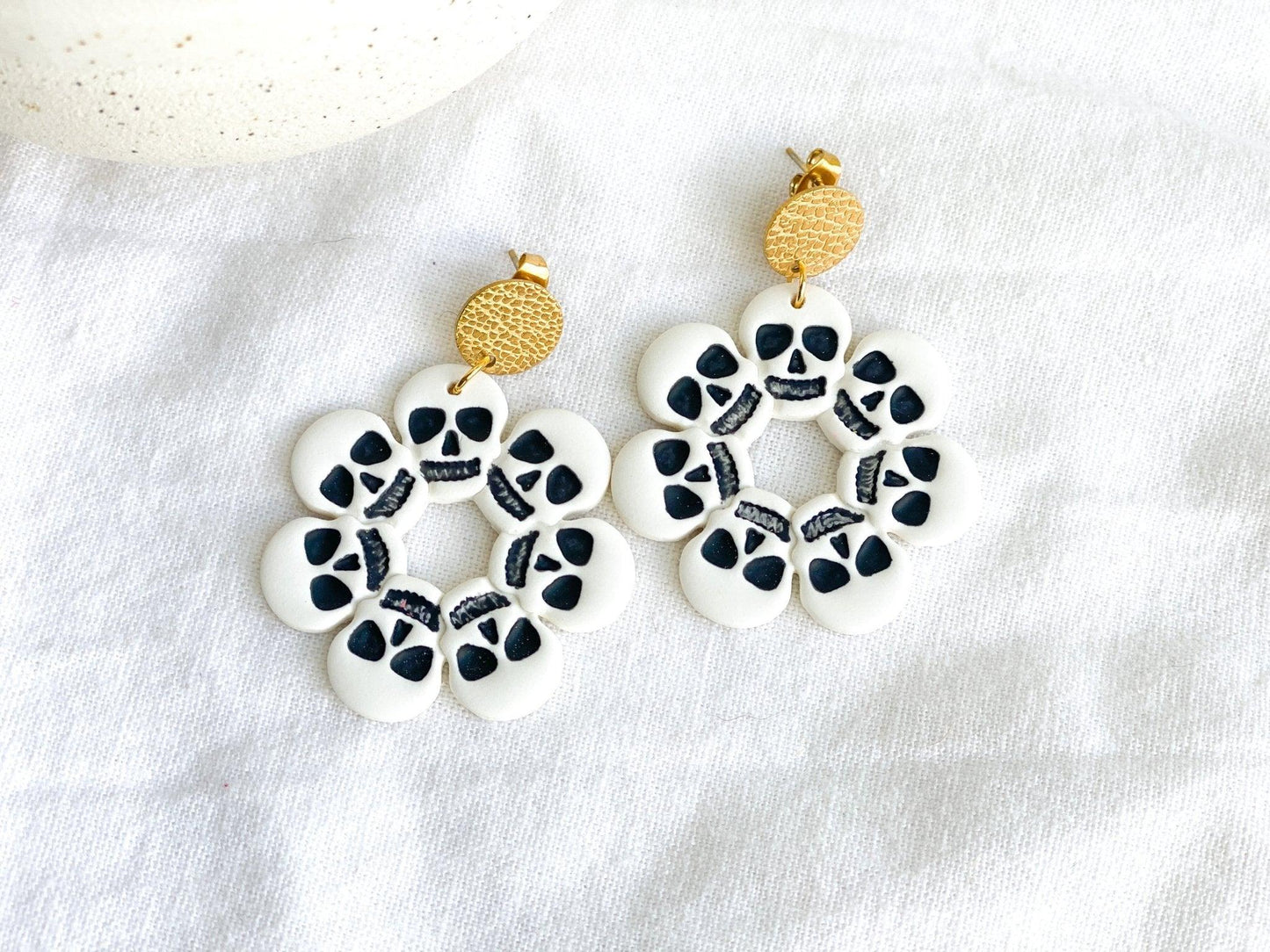 Handmade White and Black Skull Circle Earrings with Gold Surgical Steel Circle Stud Tops on White Cloth