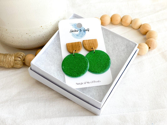 handmade sparkly green circles attached to wooden stud top on earring card that states surgical steel posts in white gift box