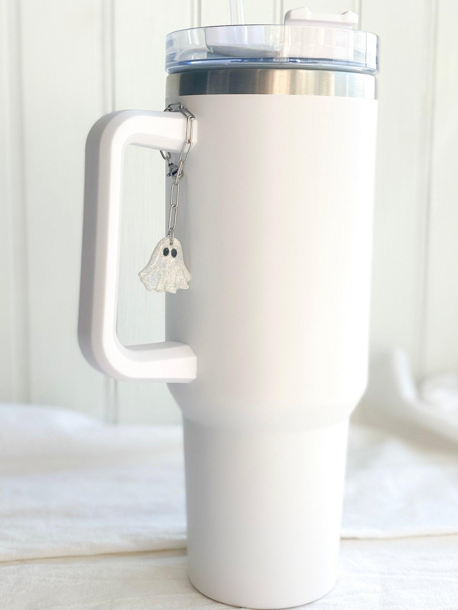 Sparkly Ghost Stanley Cup Charm Attached To Silver Stainless Steel Chain On Handle Of White Stanley Cup