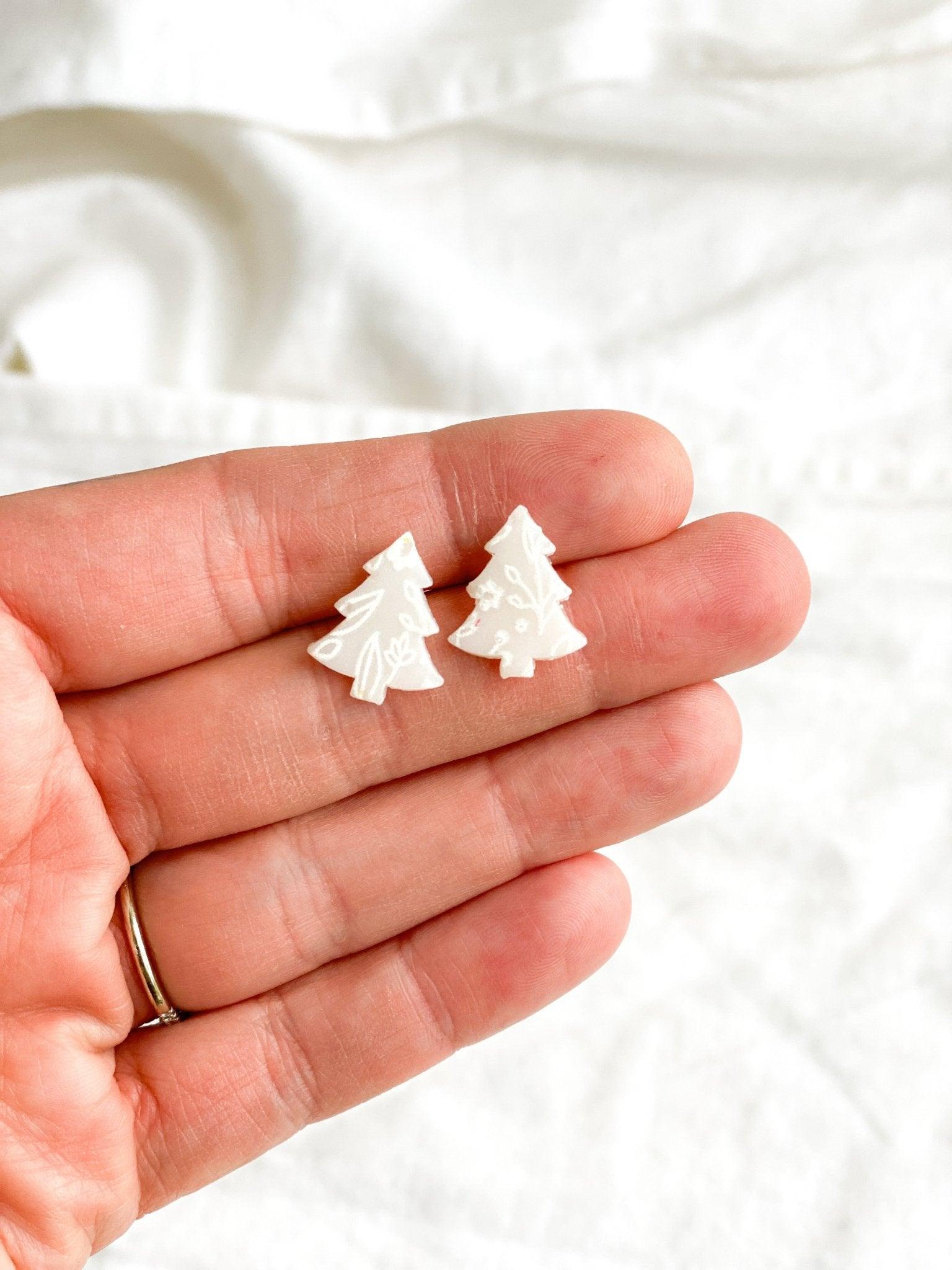 Small Handmade White Christmas Tree Stud Earrings with Surgical Steel Posts being held in human hand